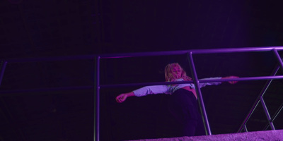 a woman standing on a metal railing at night