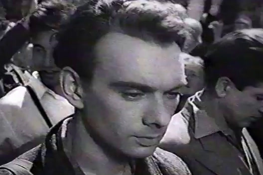 a black and white photo of a man in a crowd