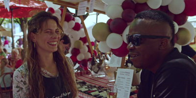 a man and a woman talking at an outdoor market