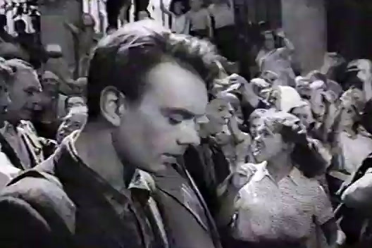 a black and white photo of a man in a crowd