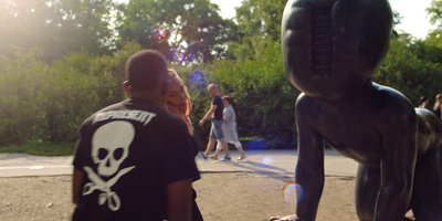 a man and a woman standing next to a statue