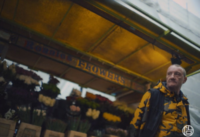 a man standing in front of a flower shop