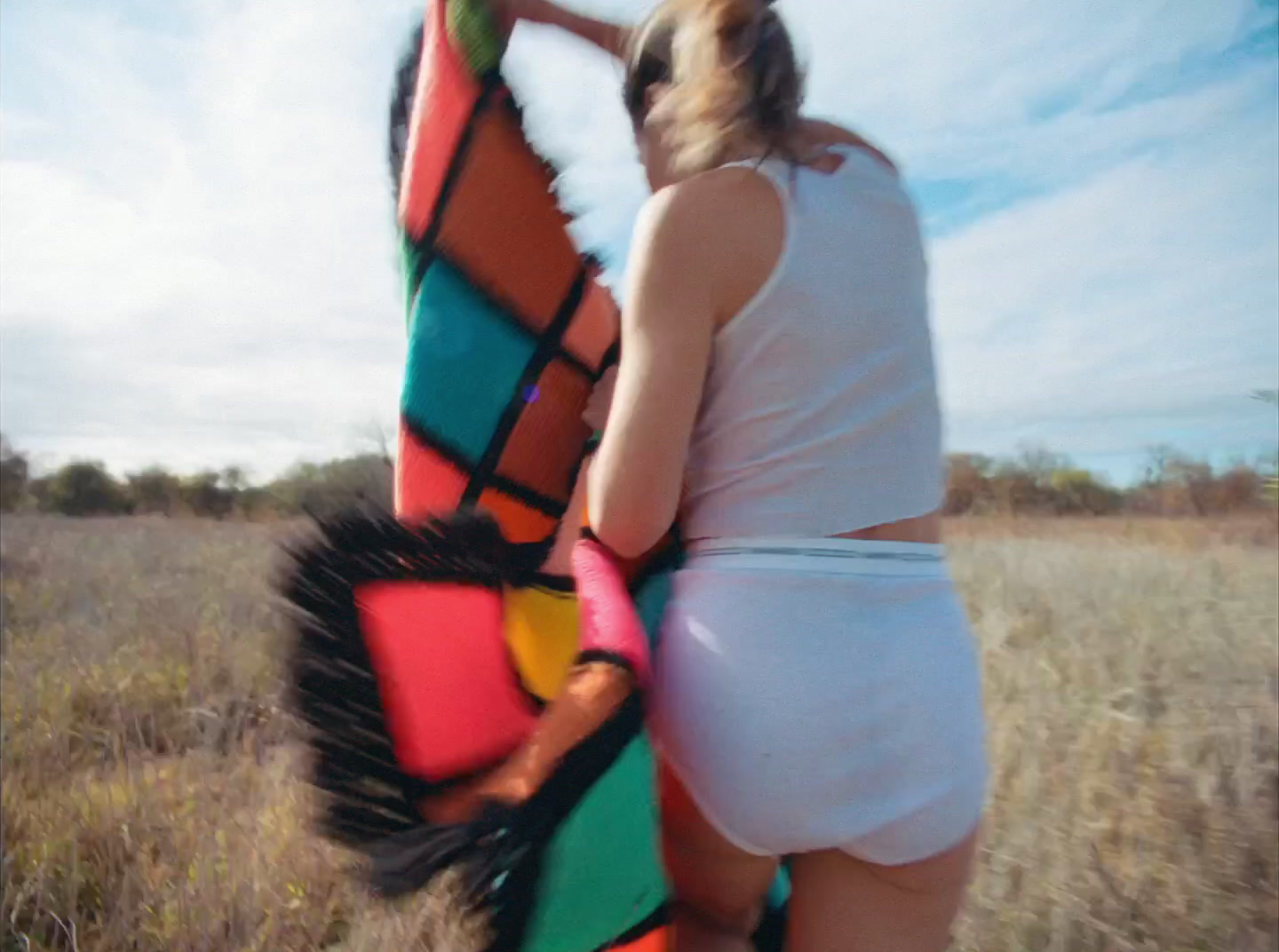 a woman in a white dress holding a colorful kite