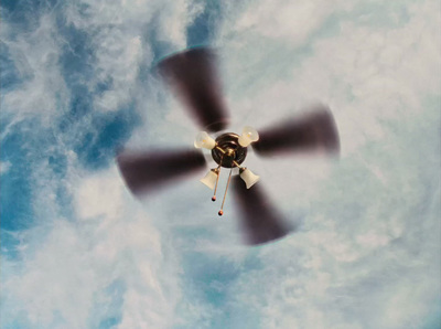 a propeller plane flying through a cloudy blue sky