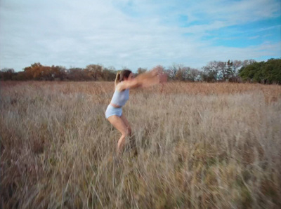 a woman in a field with a frisbee in her hand