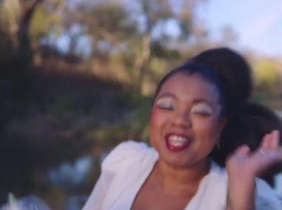 a woman smiling and holding her hands up