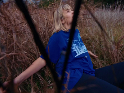 a woman sitting in a field of tall grass