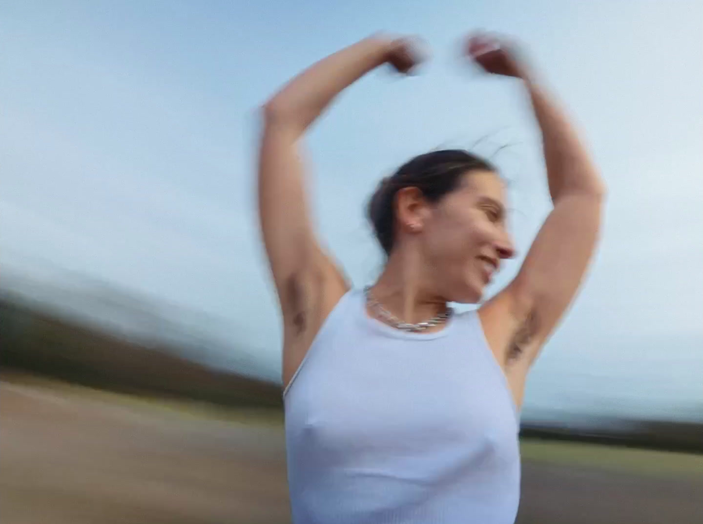 a blurry photo of a woman in a white tank top