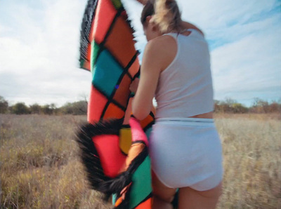 a woman holding a colorful kite in a field