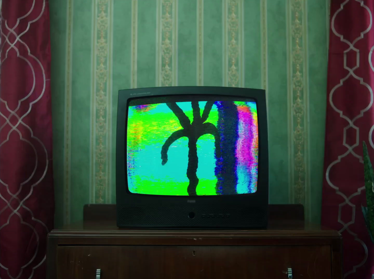 a television sitting on top of a wooden dresser