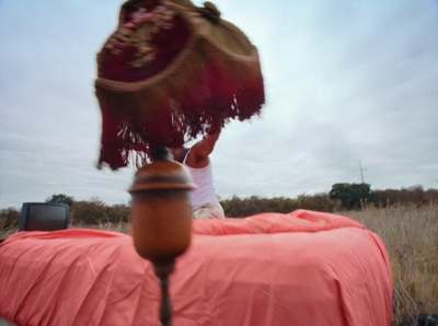 a person sitting on top of a bed in a field