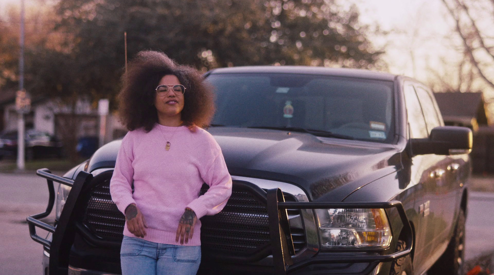 a woman standing next to a black truck