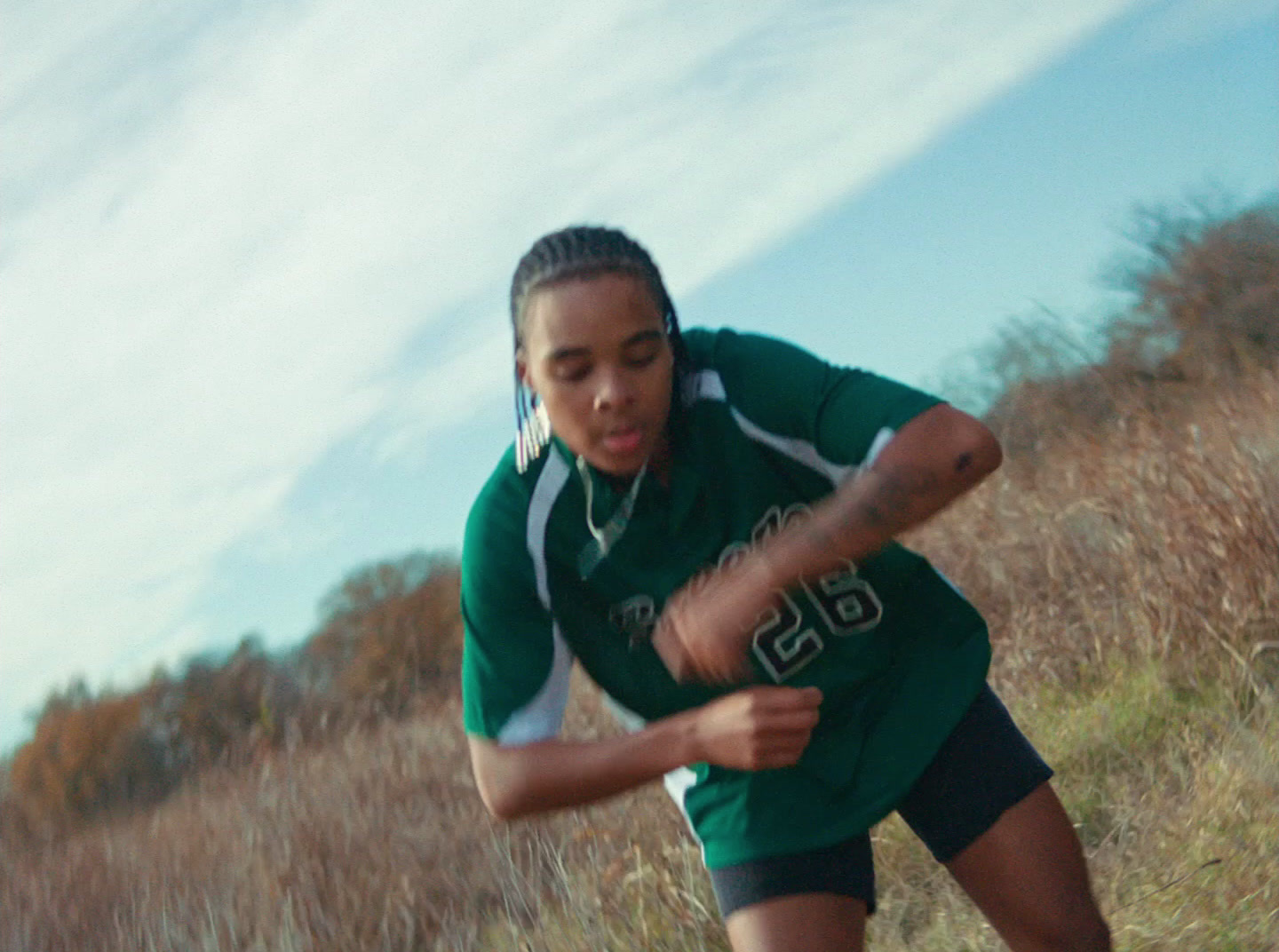 a woman in a green shirt is playing frisbee