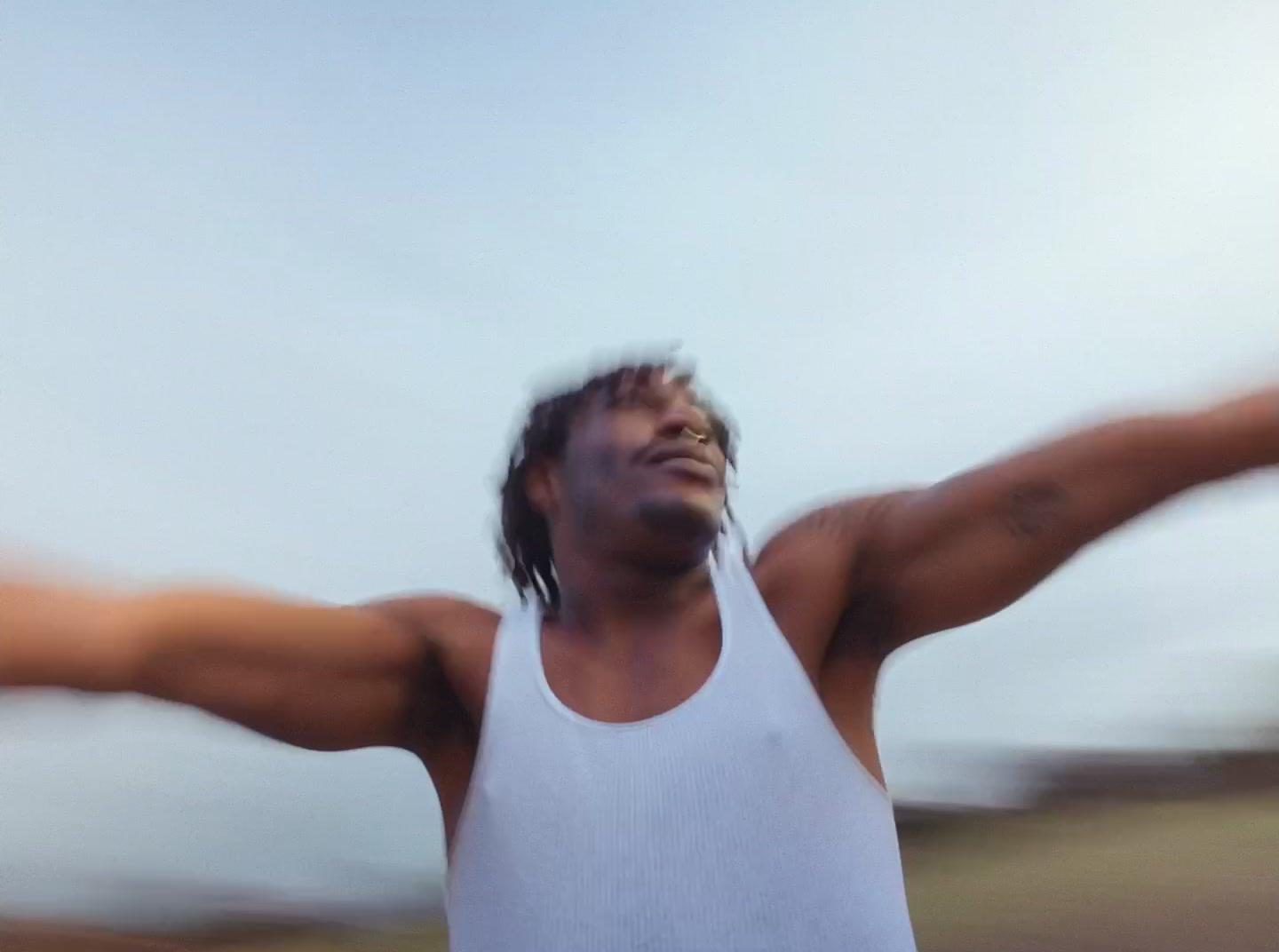 a man in a white tank top holding a frisbee