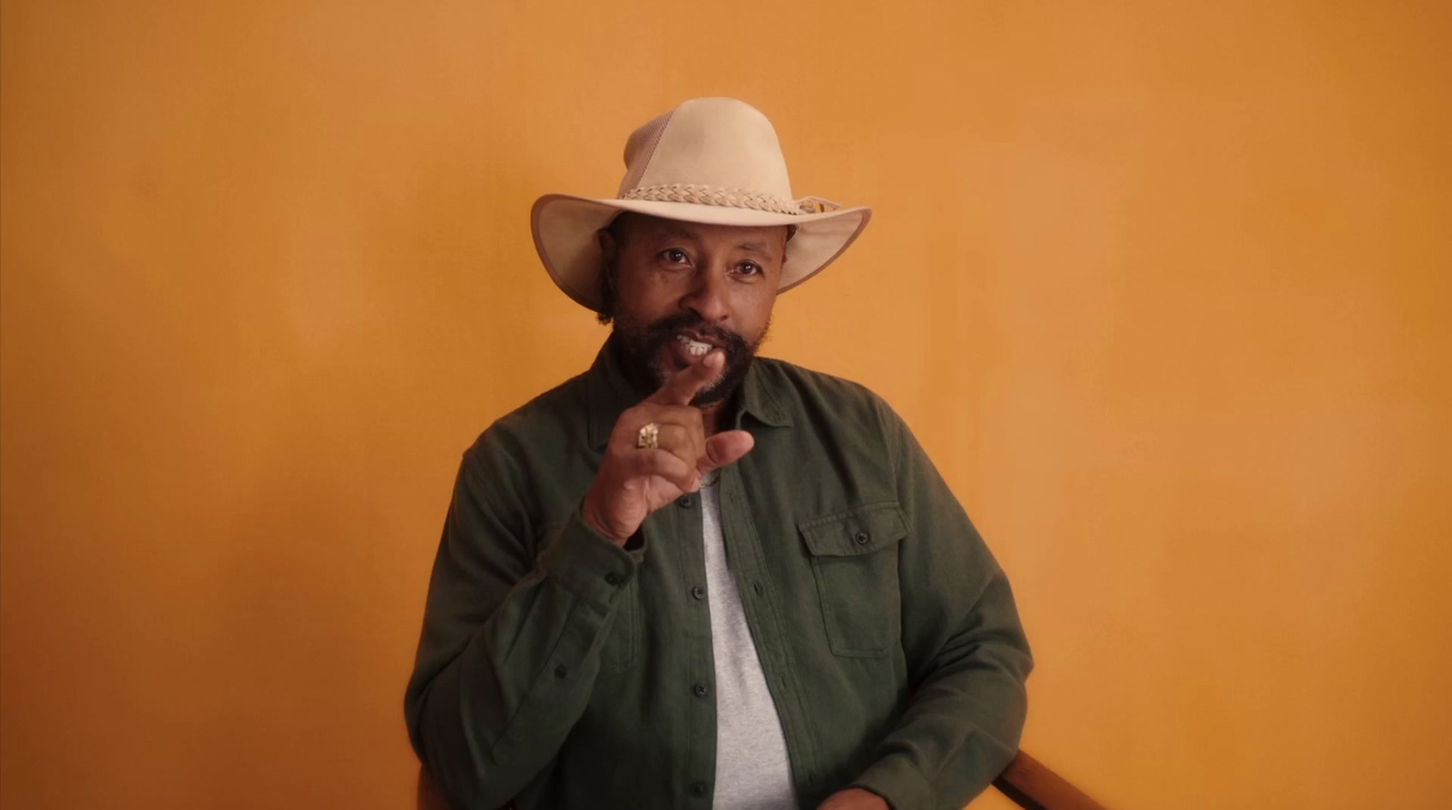 a man in a cowboy hat poses for a picture