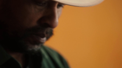 a man wearing a white hat and green shirt