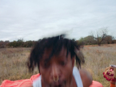 a woman with dreadlocks standing in a field