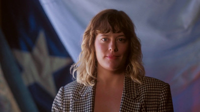 a woman standing in front of an american flag