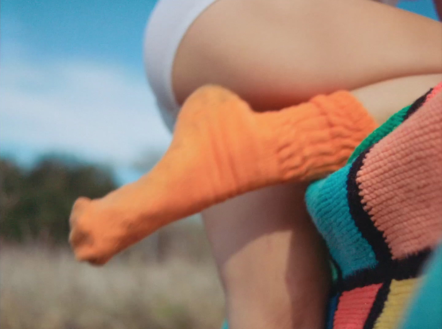 a woman in a colorful dress holding a pair of socks