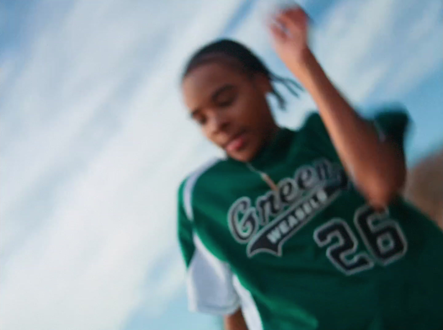 a girl in a green jersey throwing a frisbee