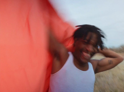 a man with dreadlocks and a white tank top