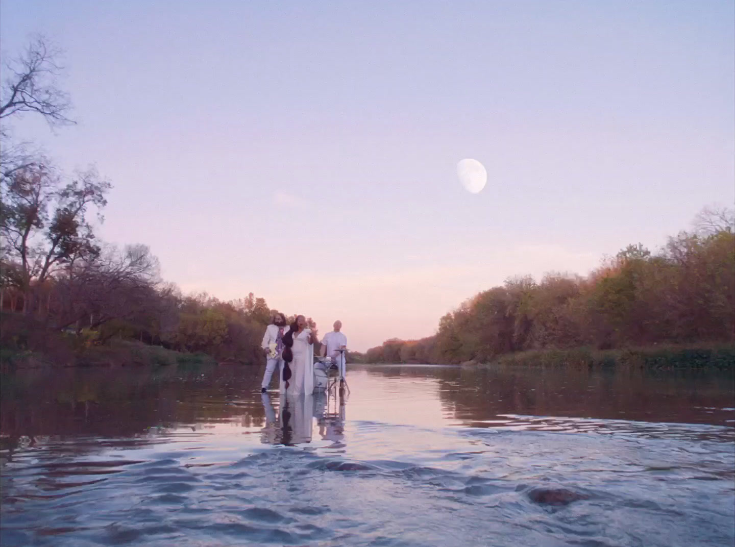 a group of people standing on top of a river