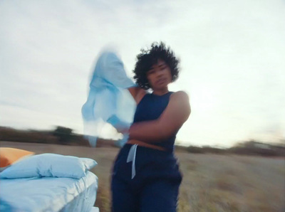 a man standing in a field holding a blue cloth