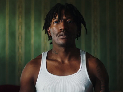 a man with dreadlocks standing in a room