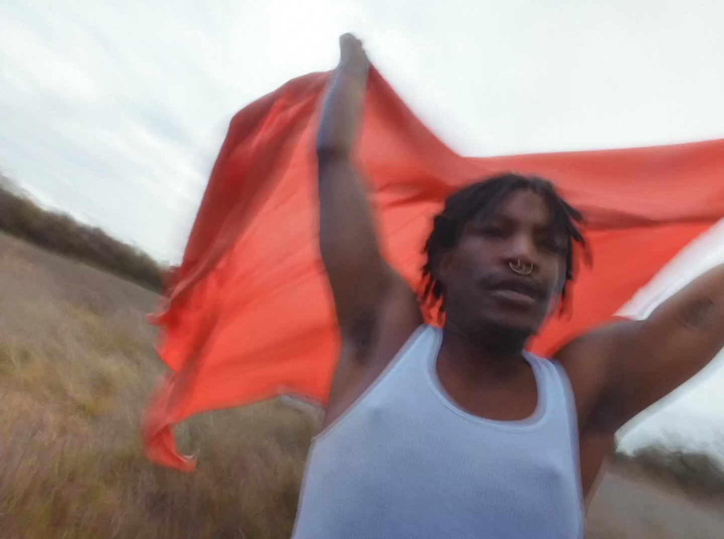 a man with dreadlocks holding a red and white flag