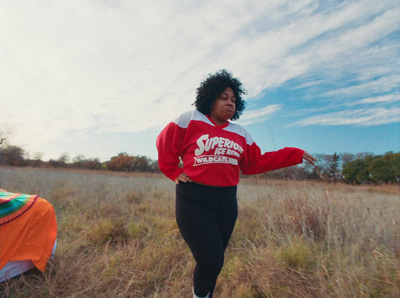 a woman standing in a field with a frisbee