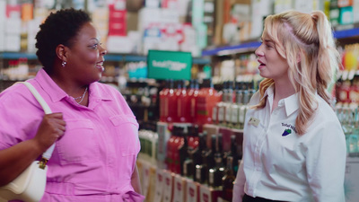 a woman talking to another woman in a store