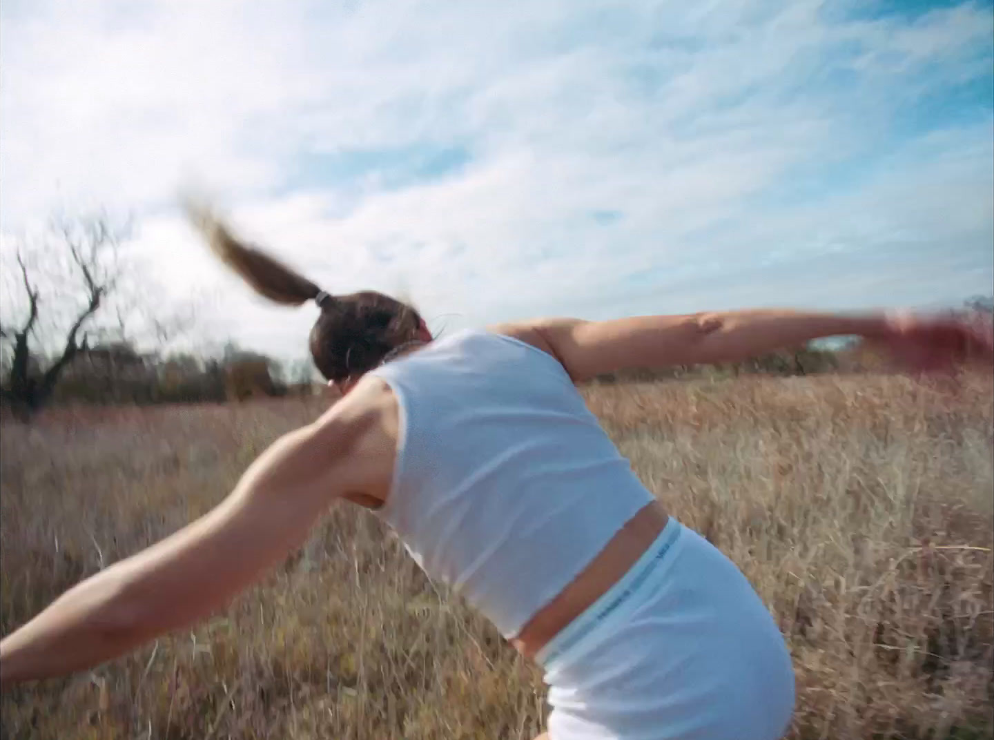 a woman in a white tank top throwing a frisbee