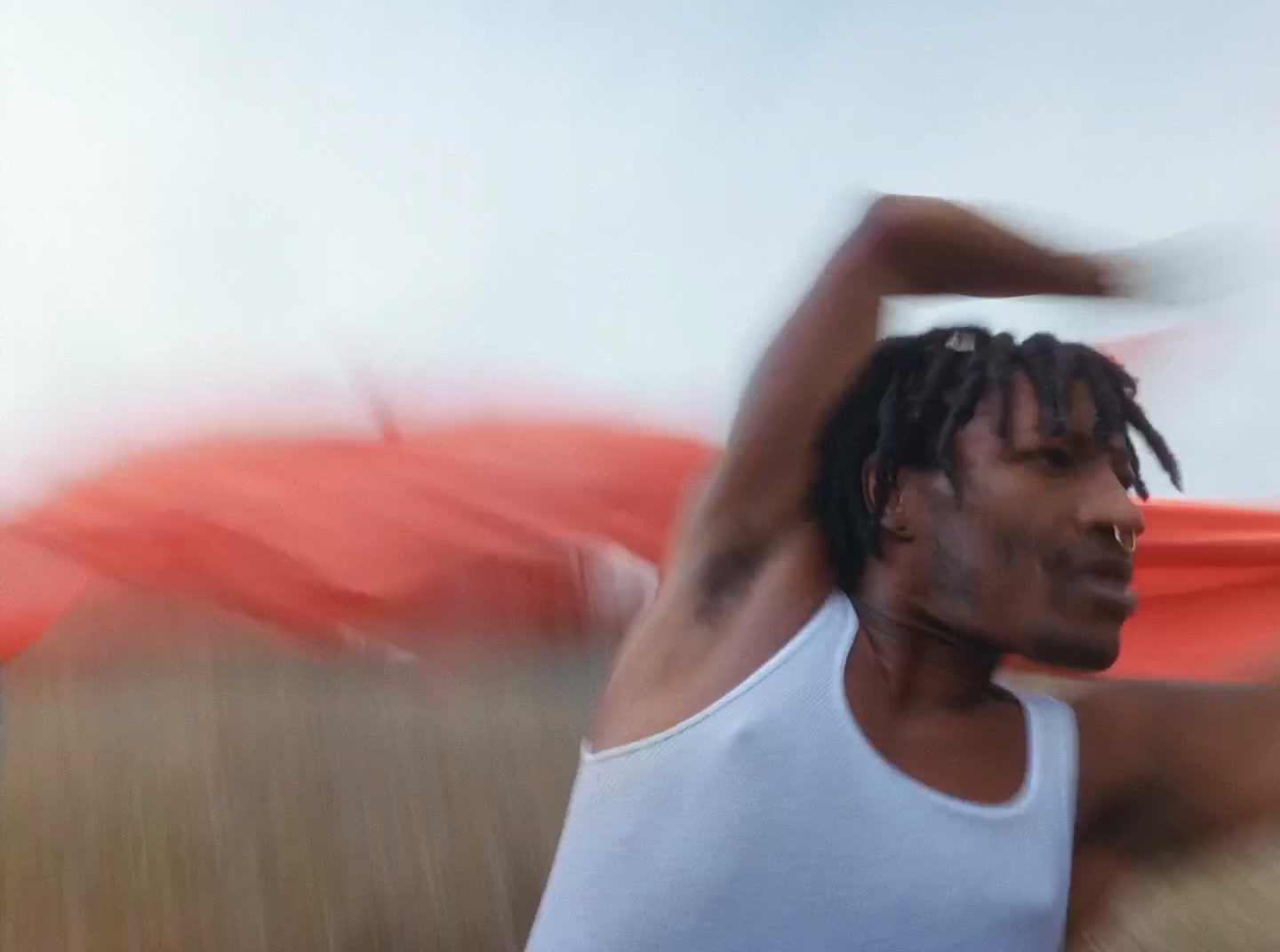 a man with dreadlocks standing in a field