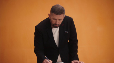 a man in a suit writing on a piece of paper