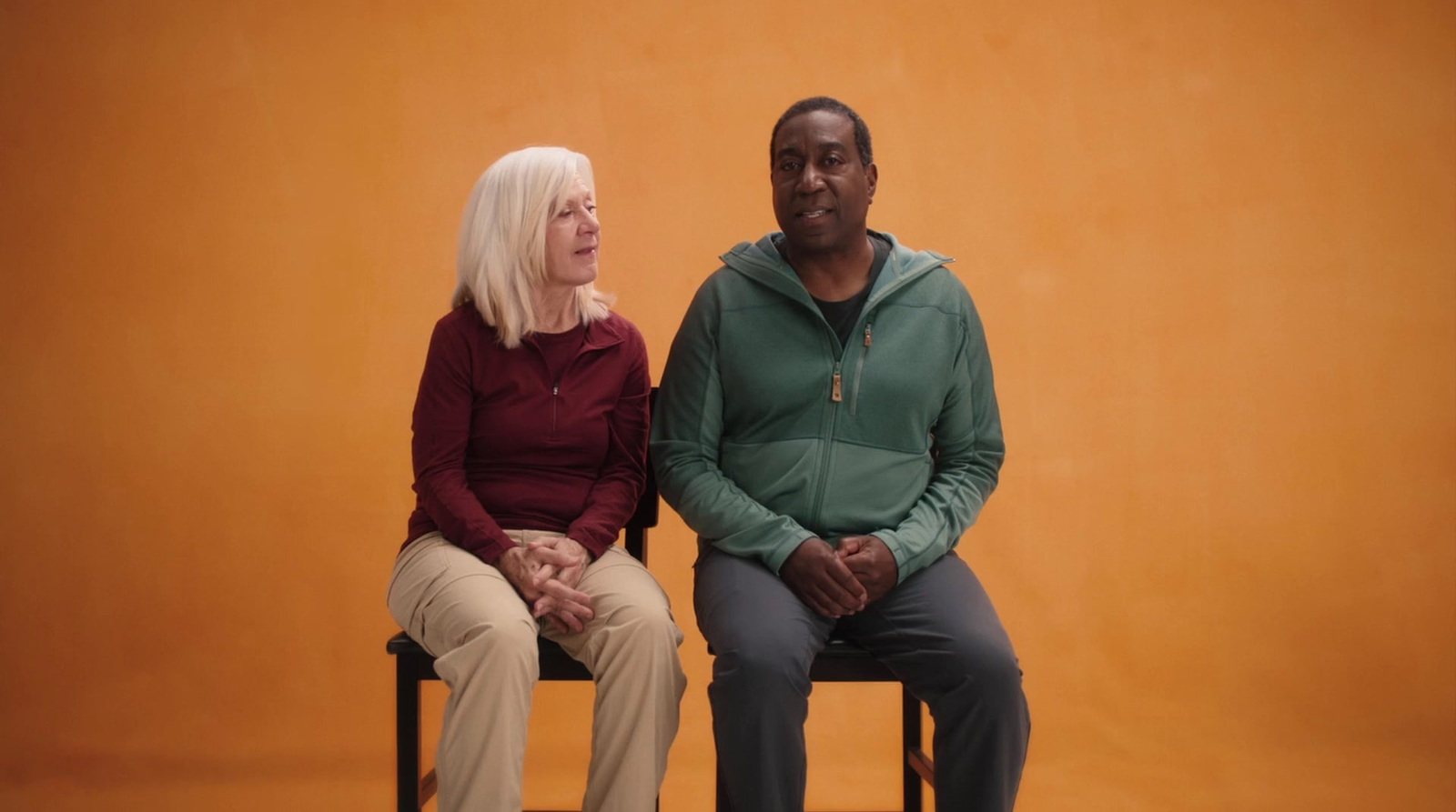 a man sitting next to a woman on a chair