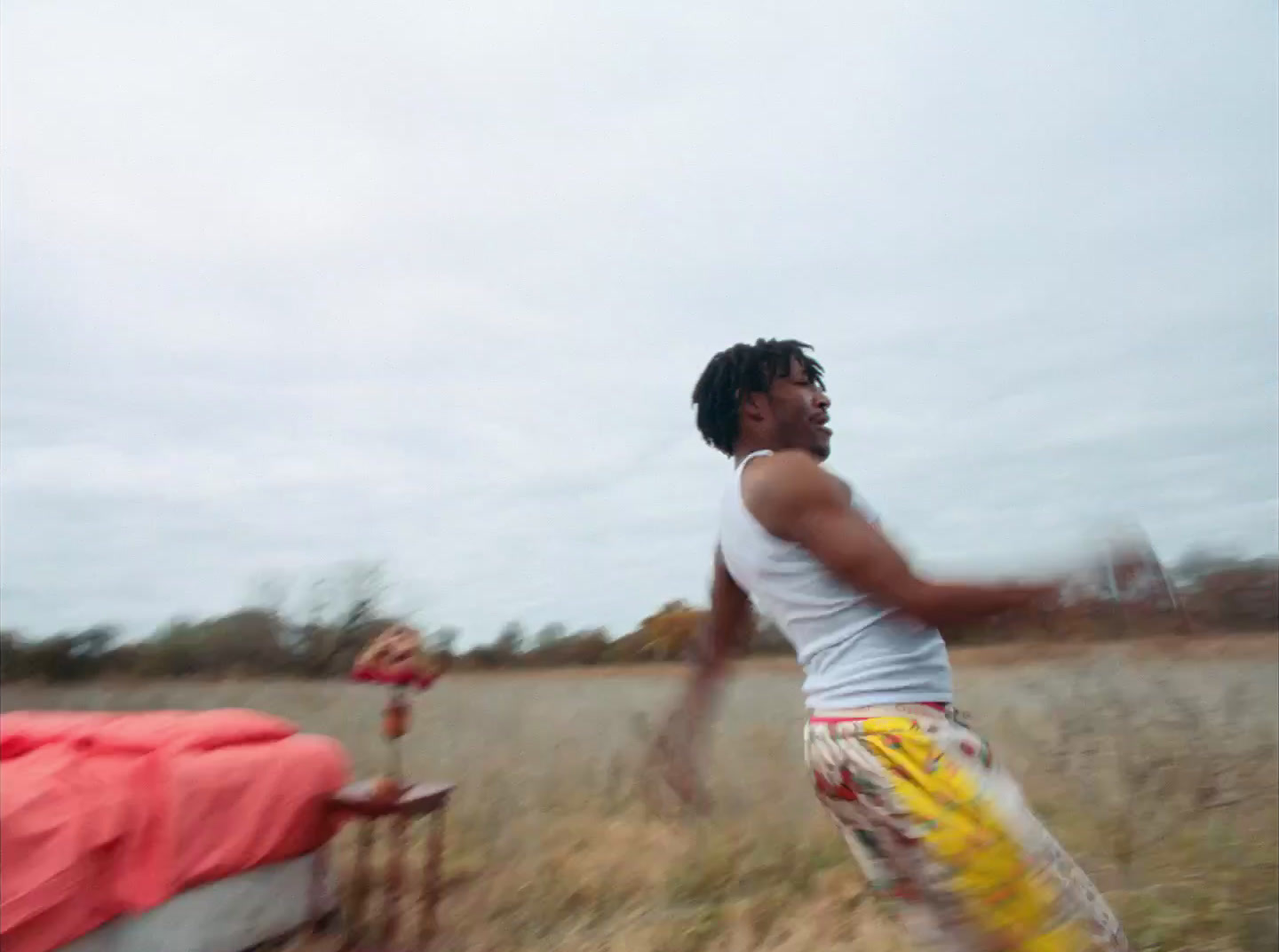 a man in a white tank top is throwing a frisbee