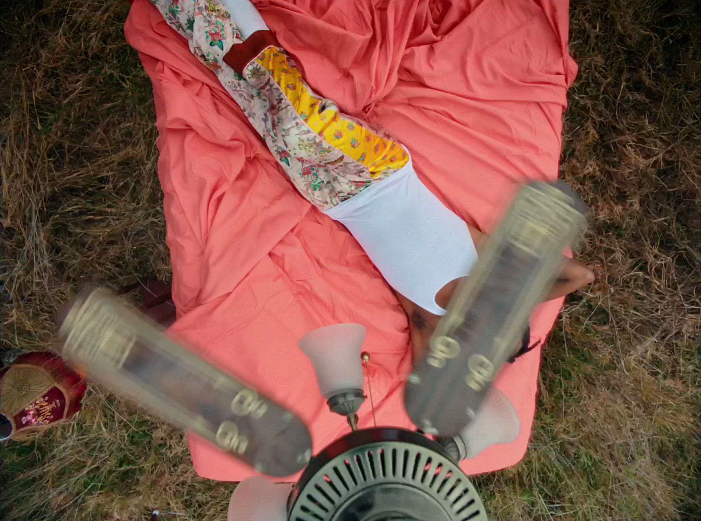 a person laying on a blanket with a bottle of ketchup