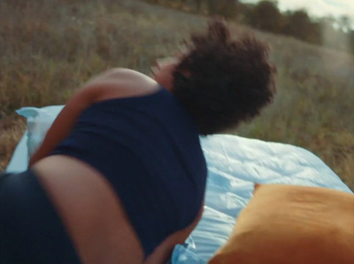 a person laying on a blanket in a field