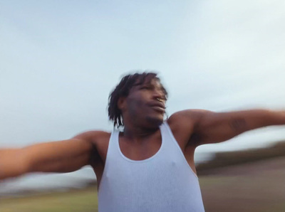 a man in a white tank top throwing a frisbee