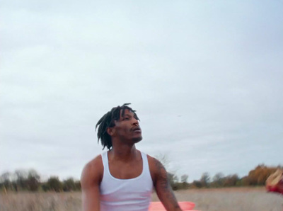 a man in a white tank top holding a red frisbee