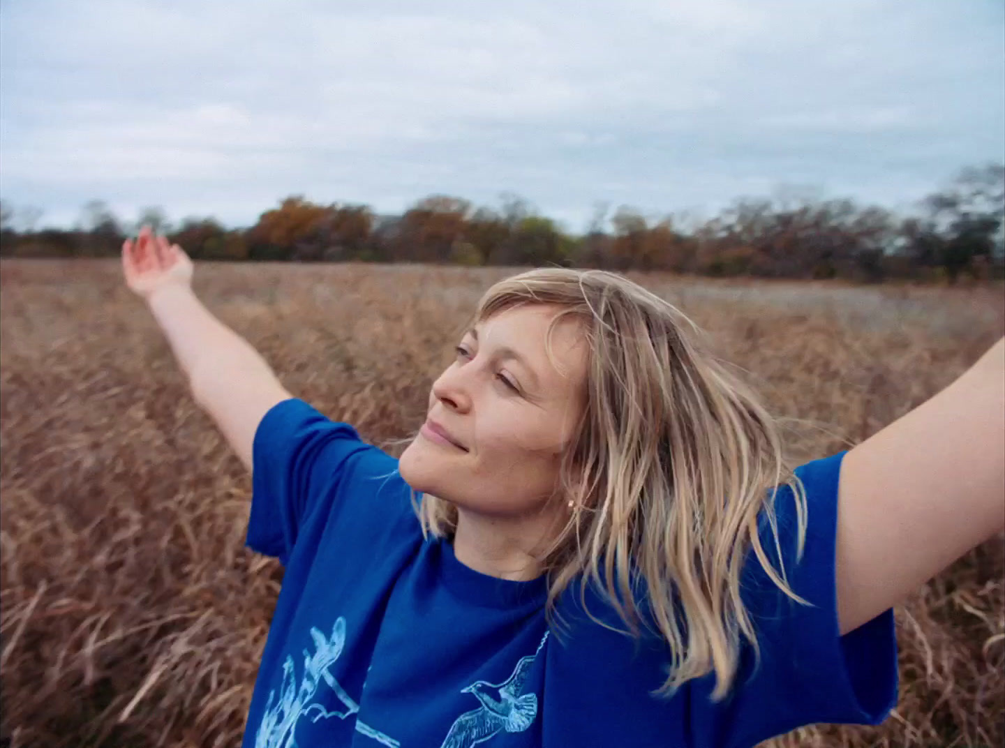 a woman standing in a field of tall grass