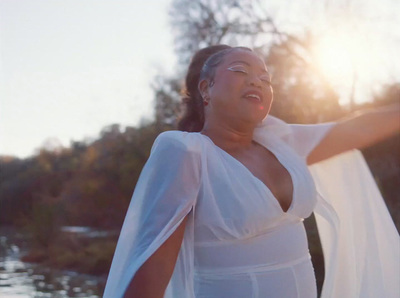 a woman in a white dress holding a white scarf