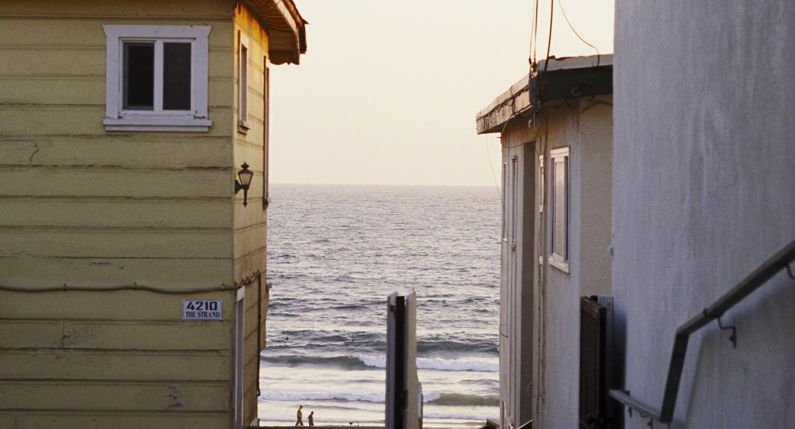 a view of a body of water from between two buildings