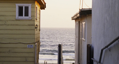 a view of a body of water from between two buildings