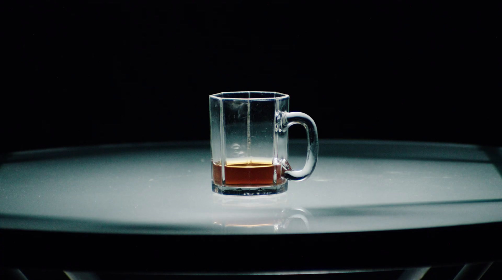 a glass of beer sitting on top of a table