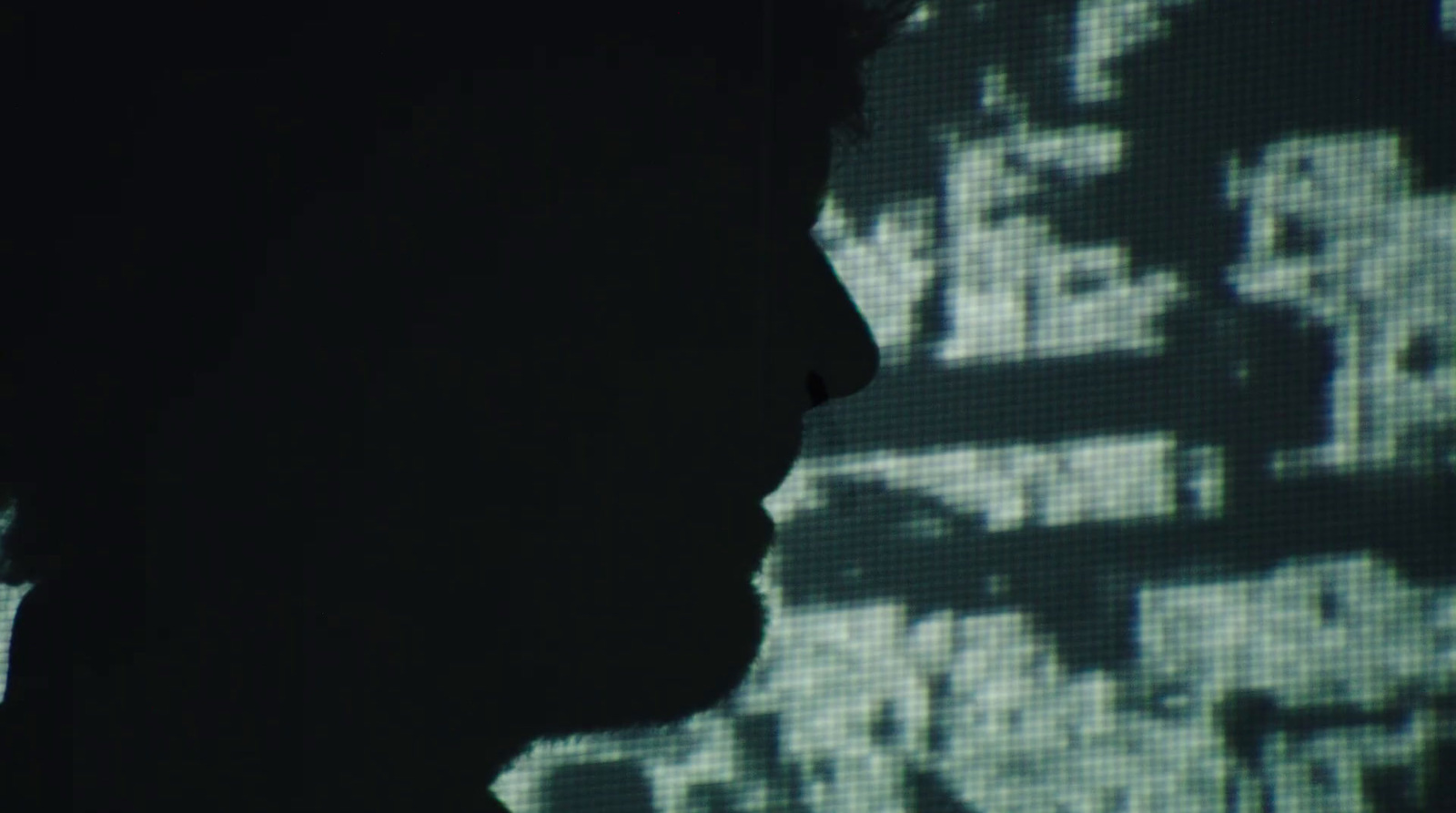 a silhouette of a person in front of a screen