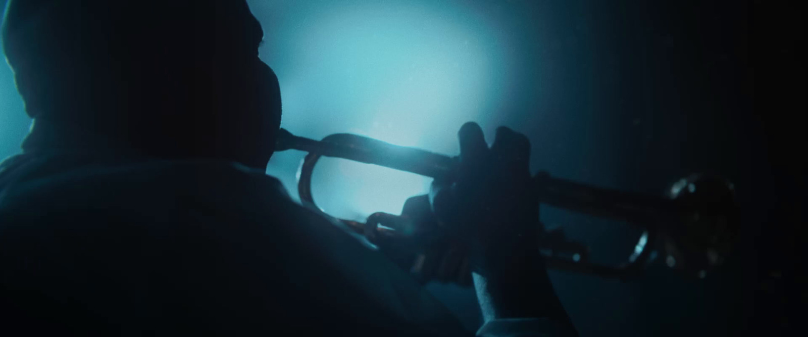 a man playing a trumpet in a dark room