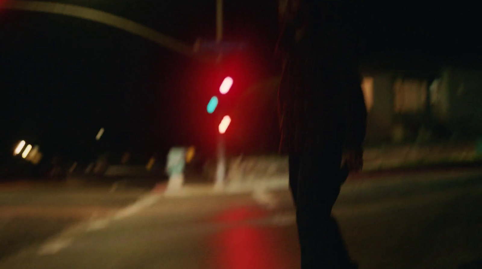 a blurry image of a person walking across a street at night