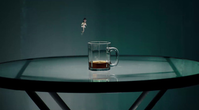 a cup of tea on a table with a fairy on it