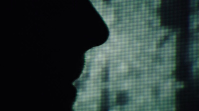 a silhouette of a person in front of a screen